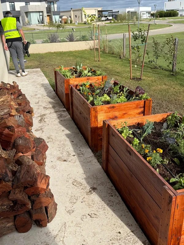 Tres cajones de madera con huerta junto al camino de entrada